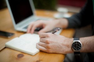 Man with wristwatch writing working